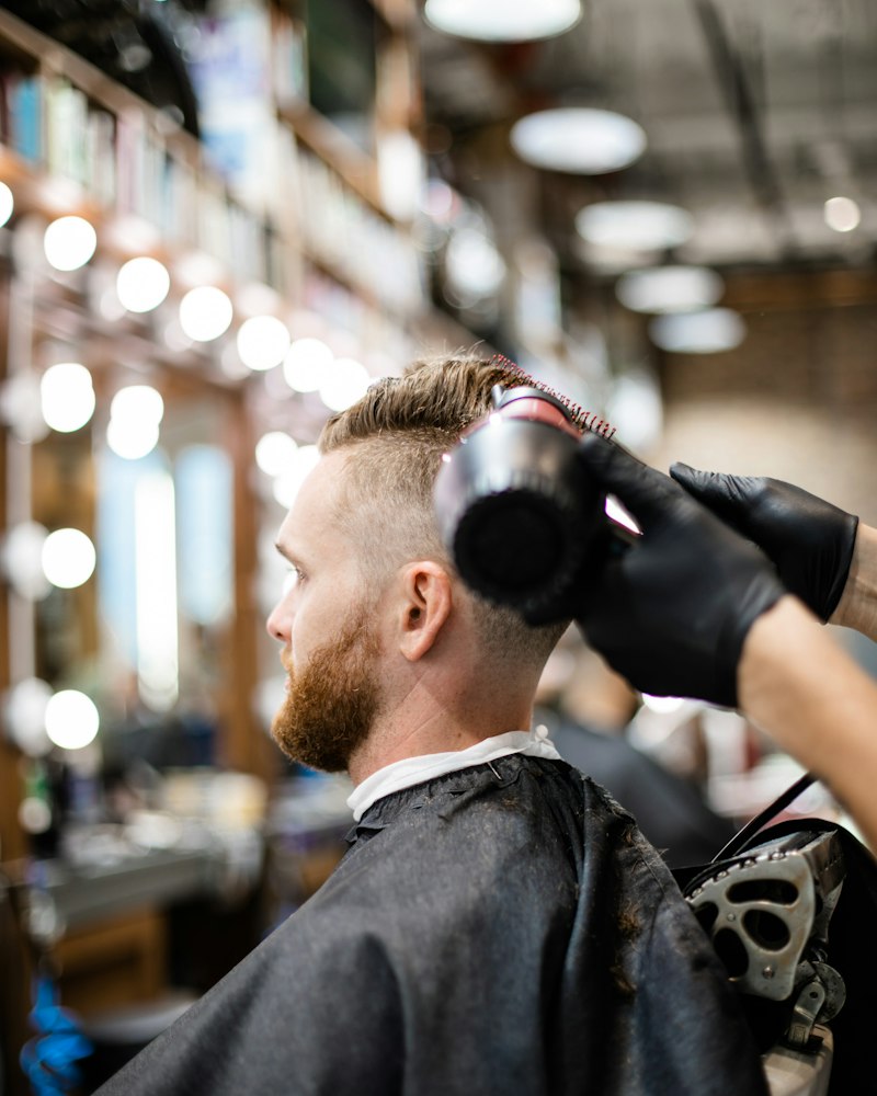 Clippers finishing the neckline of a bearded guest.