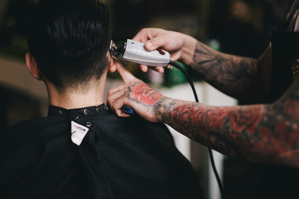 White clippers moving across a guest’s hair in a barbershop.